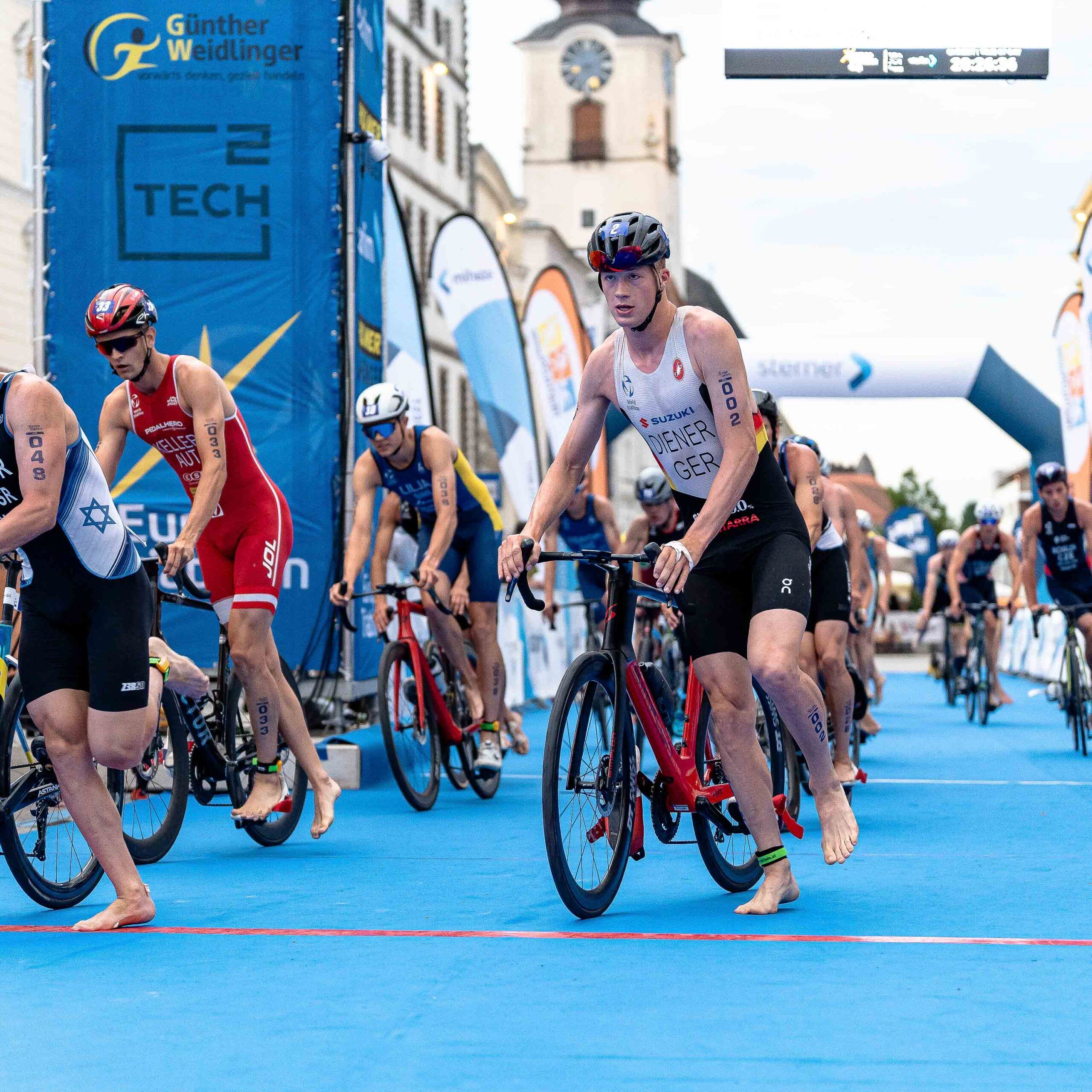 Triathleten steigen vor der Wechselzone vom Rennrad ab
