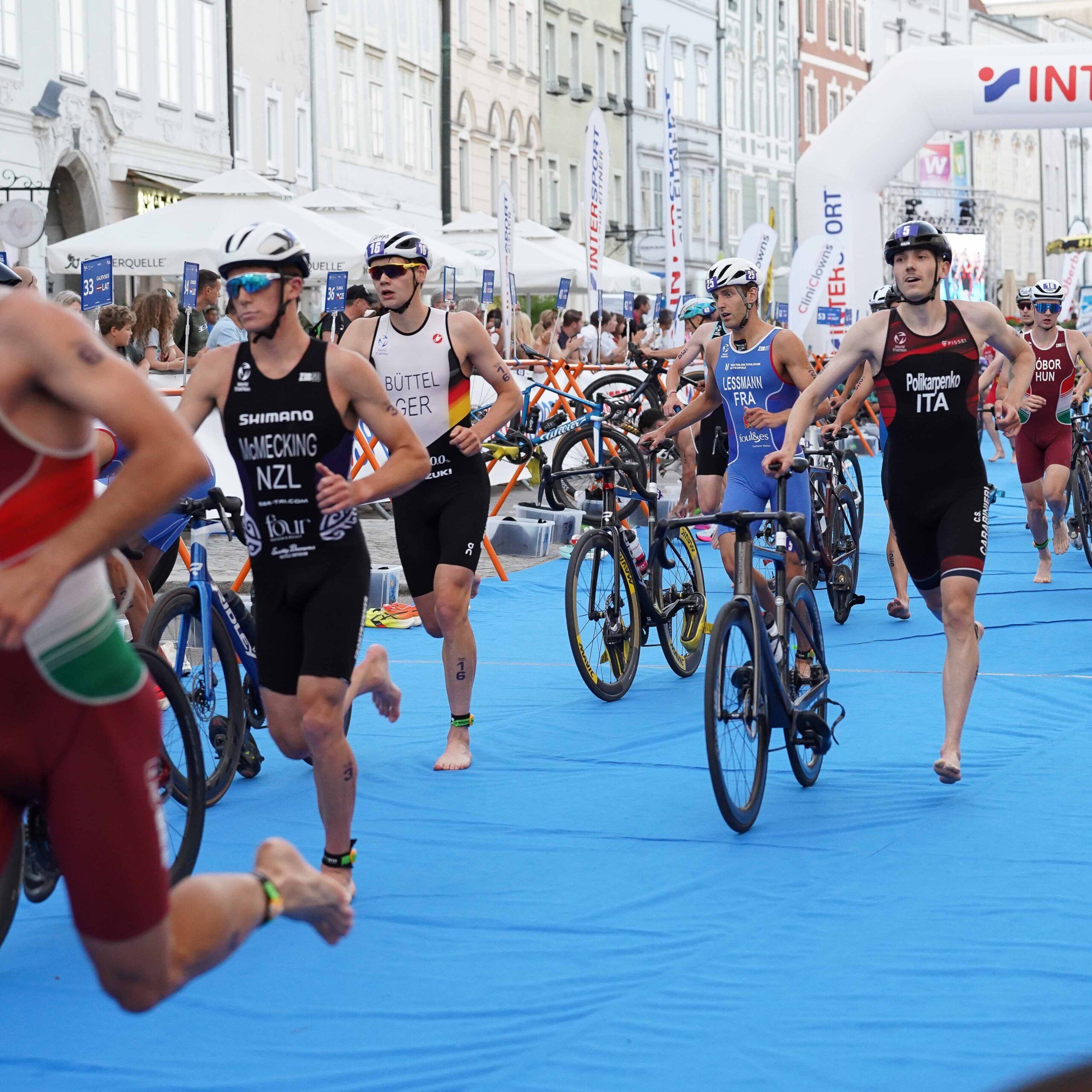Triathleten schieben ihr Rad in der Wechselzone